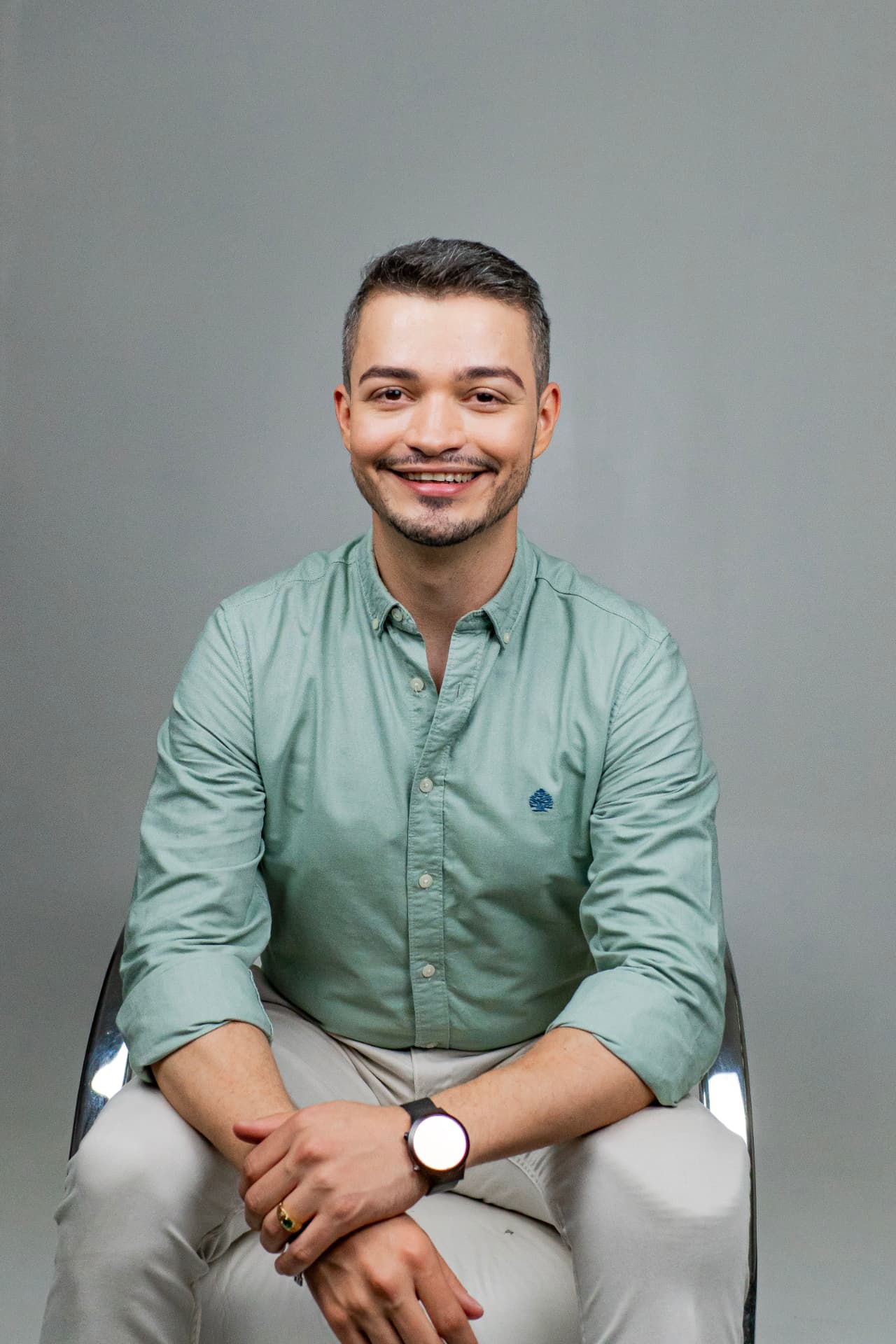 Dr. Tiago Barros, dermatologista em Juazeiro do Norte, sentado e sorrindo